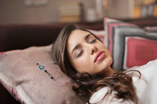 A woman peacefully sleeping indoors on a pillow, exuding comfort and relaxation.