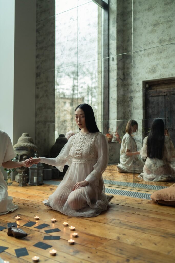 Dos mujeres participan en un sereno ritual en interiores rodeadas de velas, creando un ambiente místico, según las opiniones es uno de los mejores métodos