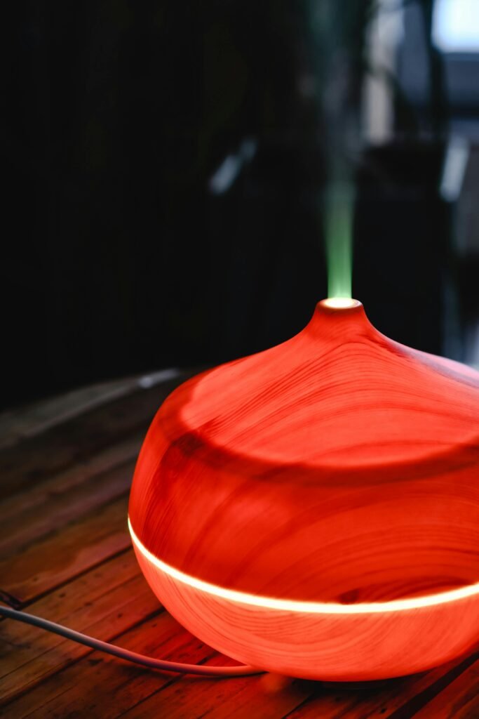 A close-up of a glowing red wooden essential oil diffuser on a table, perfect for aromatherapy.