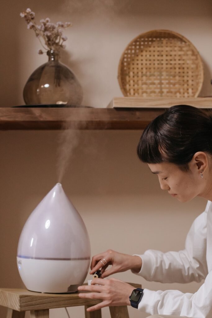 A person adjusting a humidifier in a cozy, minimalist interior setting.