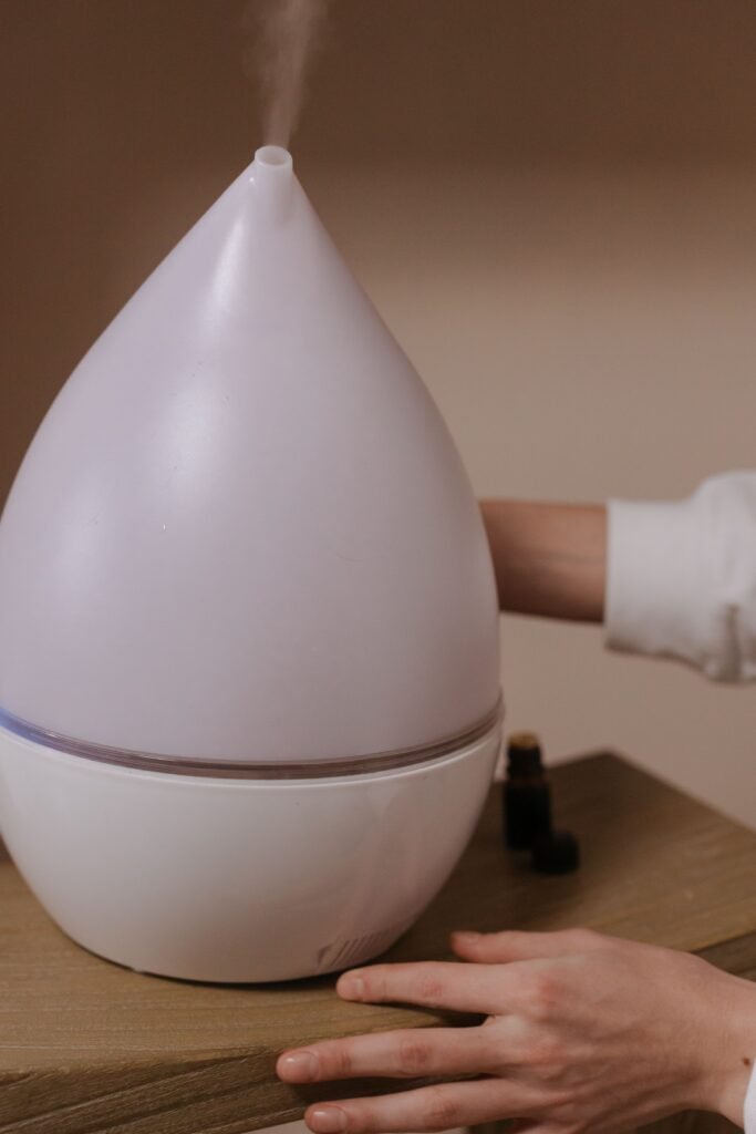 Photo of a modern humidifier emitting mist on a wooden surface indoors, with a warm ambiance.