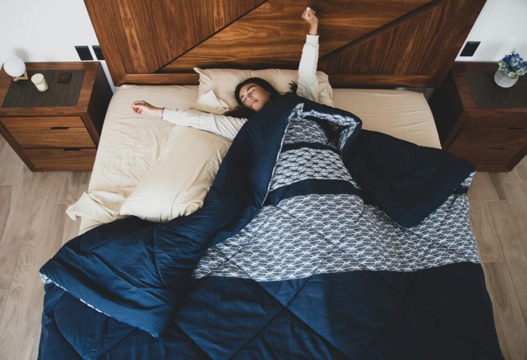 Una mujer se estira y se relaja en un acogedor dormitorio, creando una serena atmósfera matutina usando nos delos mejores edredones de cama 