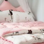 A cozy bedroom with pink bedding and animal patterns, perfect for relaxation.